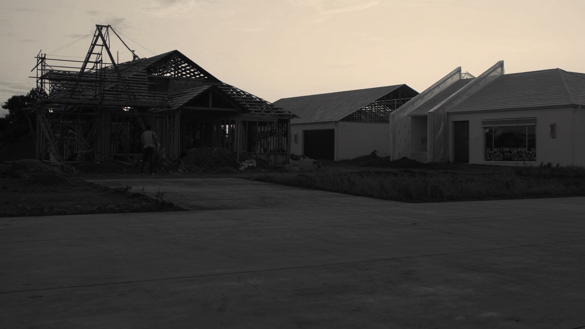 Modern luxury home under construction at dusk.